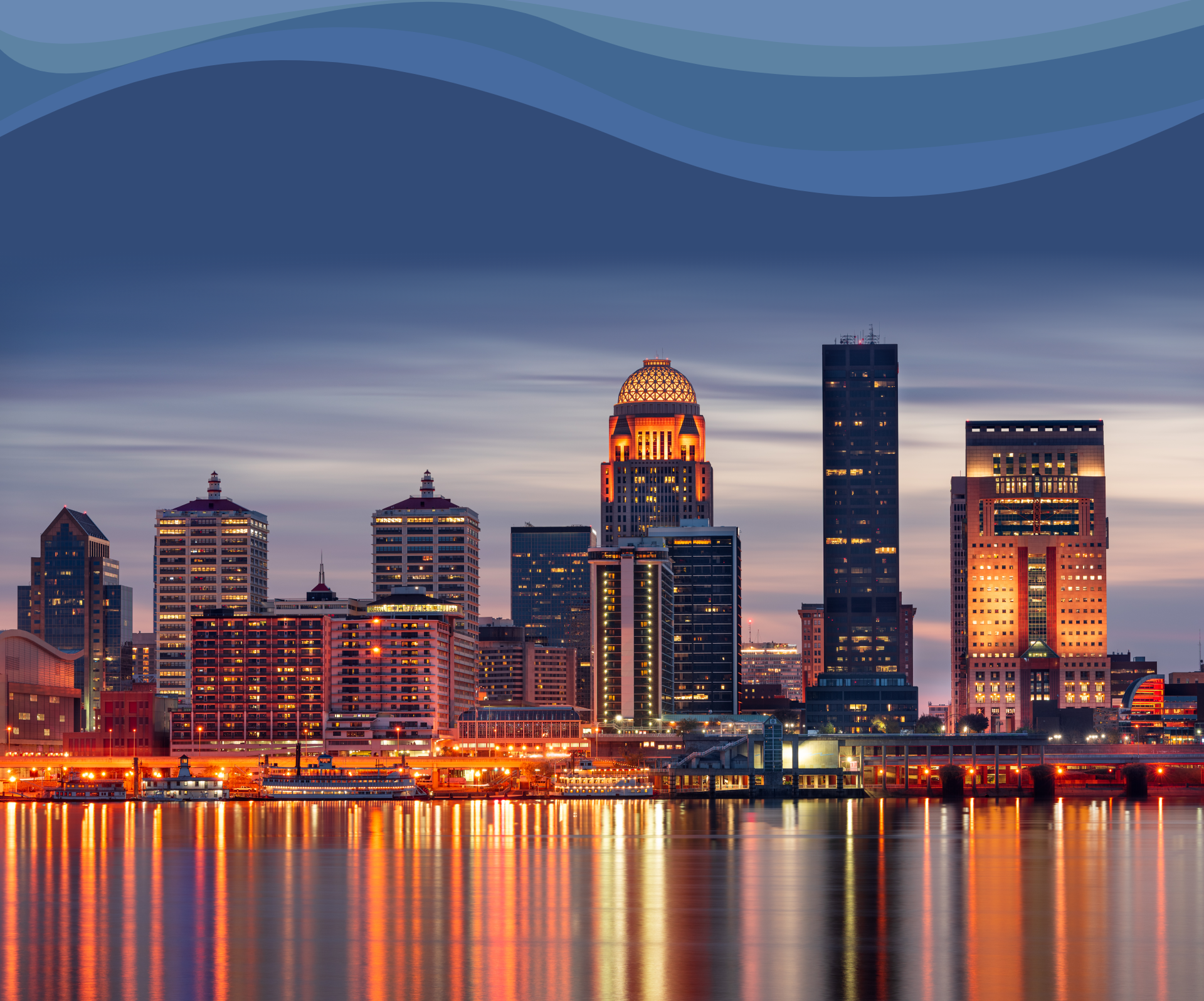 Louisville, Kentucky night time city skyline with city lights reflecting down across a body of water
